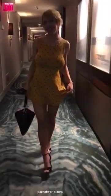 Busty blonde removes dress in hotel hallway